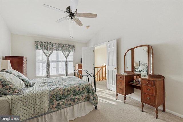 carpeted bedroom with vaulted ceiling, baseboards, and ceiling fan