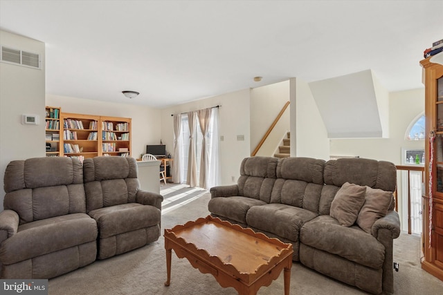 living area with visible vents and light colored carpet