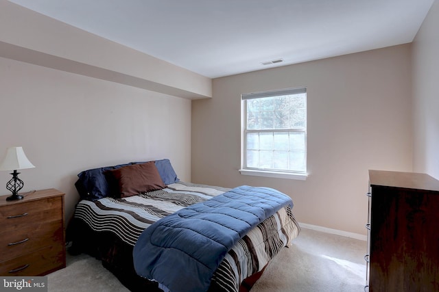 bedroom with light colored carpet, visible vents, and baseboards