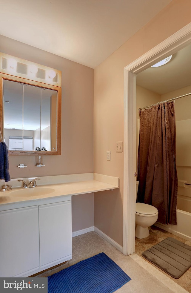 bathroom with toilet, vanity, baseboards, and shower / bath combo