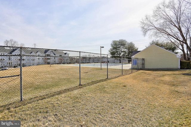 view of yard with a residential view, a tennis court, and fence