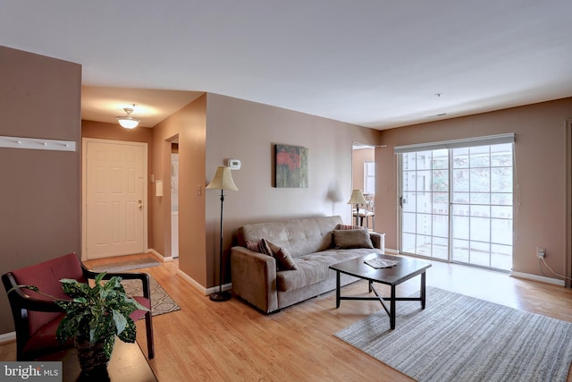 living area featuring light wood-style floors and baseboards