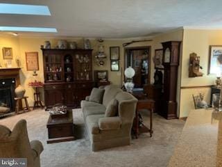 living area featuring a skylight, a fireplace, and crown molding