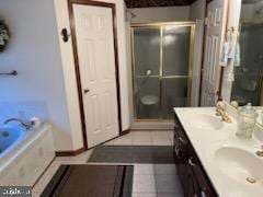 full bathroom with double vanity, a sink, a shower stall, a bath, and tile patterned floors