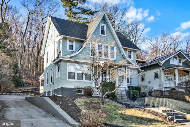 view of front of property with concrete driveway and a shingled roof