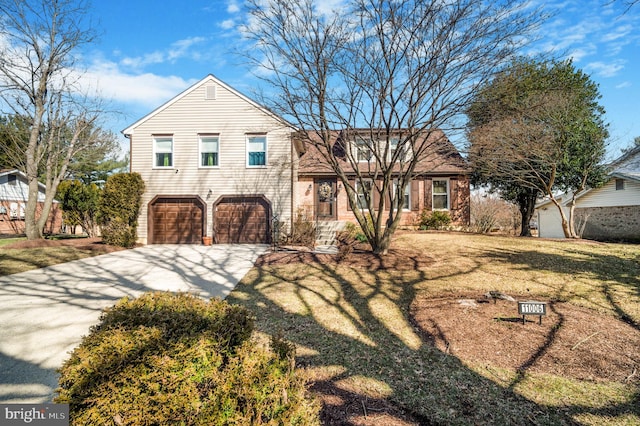 split level home with concrete driveway, a garage, and a front lawn