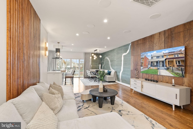 living area with visible vents, recessed lighting, and wood finished floors