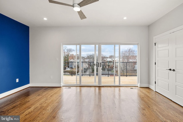 spare room featuring recessed lighting, wood finished floors, and baseboards