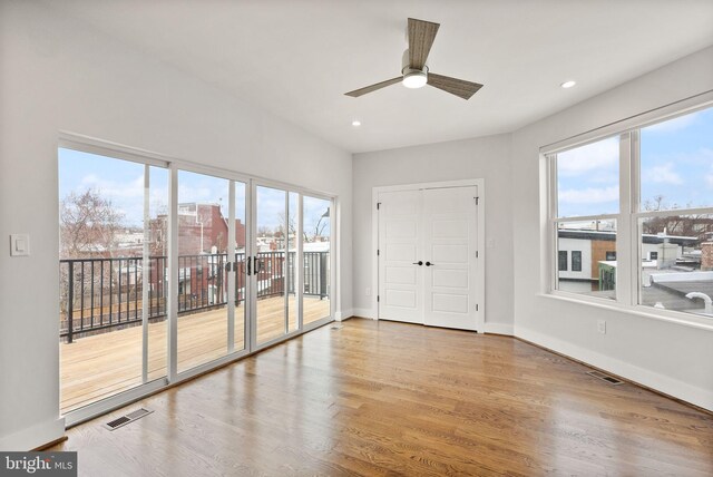 spare room with recessed lighting, wood finished floors, visible vents, and baseboards