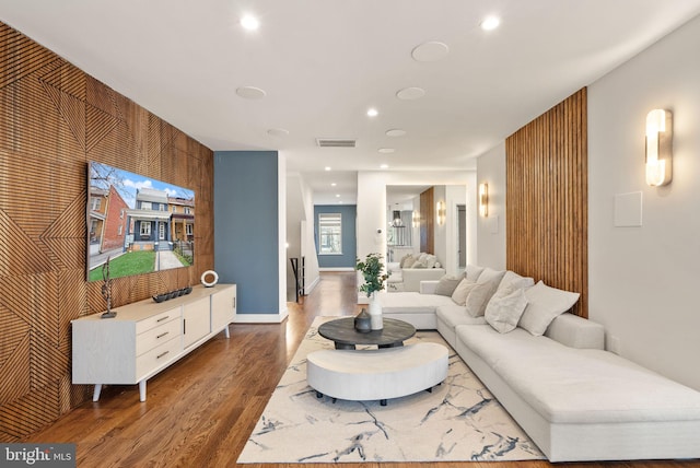 living area featuring visible vents, recessed lighting, baseboards, and wood finished floors