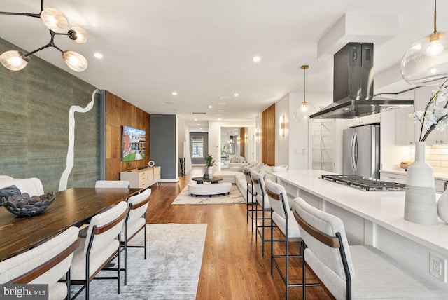 dining space with recessed lighting, baseboards, and wood finished floors