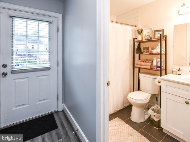 full bathroom featuring toilet, a shower with shower curtain, vanity, baseboards, and tile patterned floors