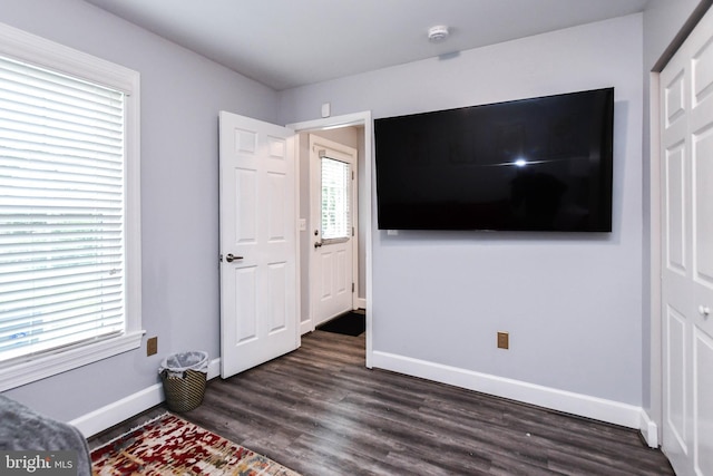 bedroom with dark wood-style floors and baseboards