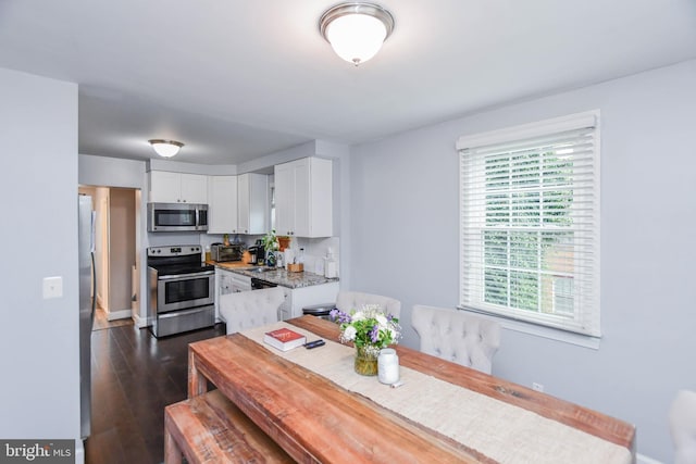 dining area featuring dark wood-style floors and a toaster