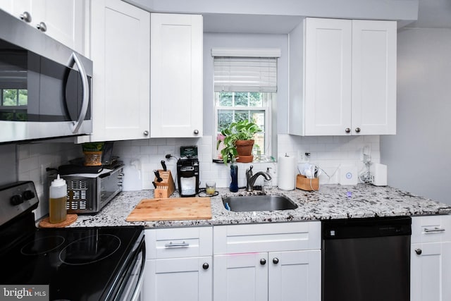 kitchen featuring stainless steel appliances, a sink, and white cabinetry