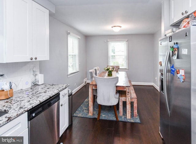 dining area with dark wood-type flooring and baseboards