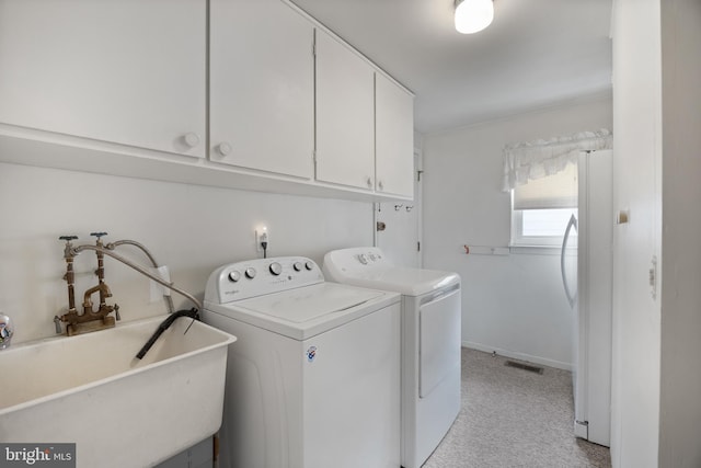 laundry area with visible vents, light carpet, independent washer and dryer, a sink, and cabinet space