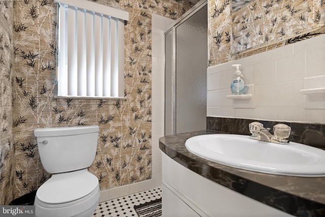 full bathroom with tile patterned flooring, tile walls, toilet, a stall shower, and vanity