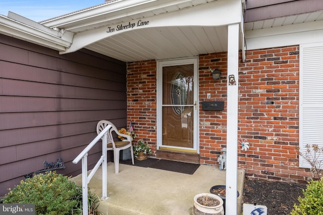 entrance to property featuring brick siding