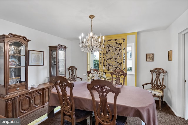 dining room with dark carpet, baseboards, and an inviting chandelier