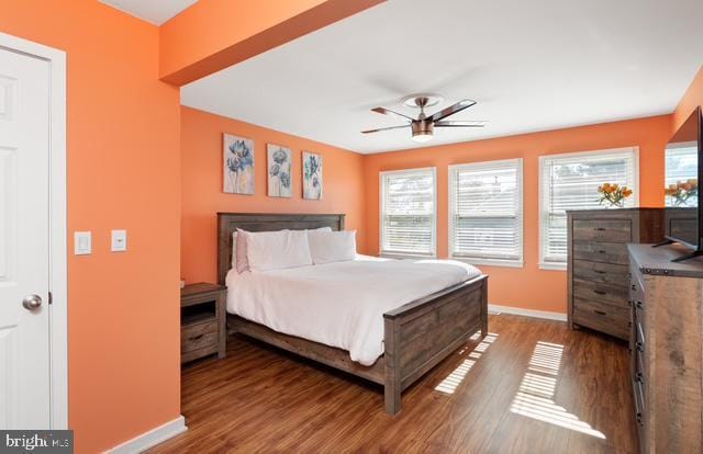 bedroom featuring wood finished floors, a ceiling fan, and baseboards