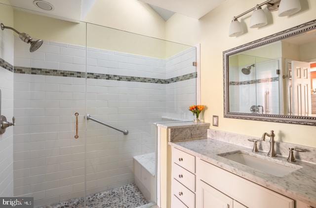 bathroom with a shower stall and vanity