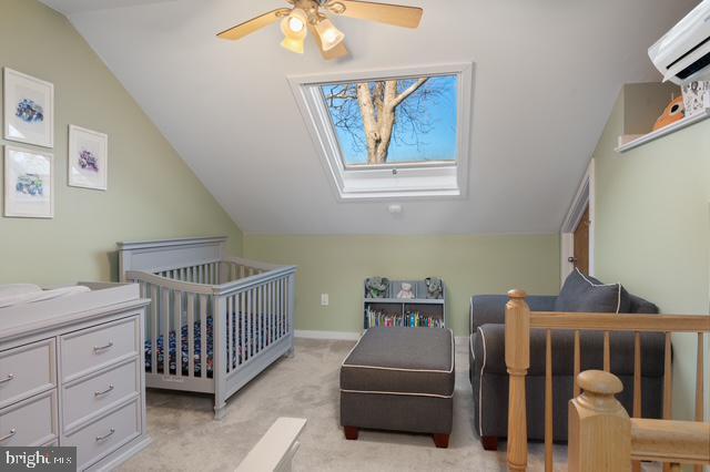 bedroom featuring a wall unit AC, ceiling fan, light carpet, and lofted ceiling