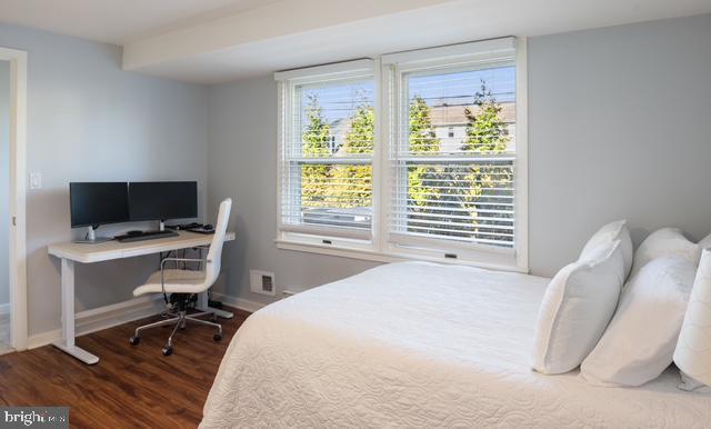 bedroom featuring dark wood-style floors and baseboards