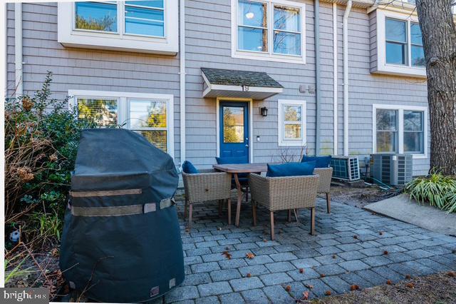 view of patio with outdoor dining area, central AC, and area for grilling