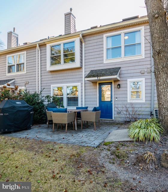 rear view of house with a patio area, a chimney, and an outdoor living space