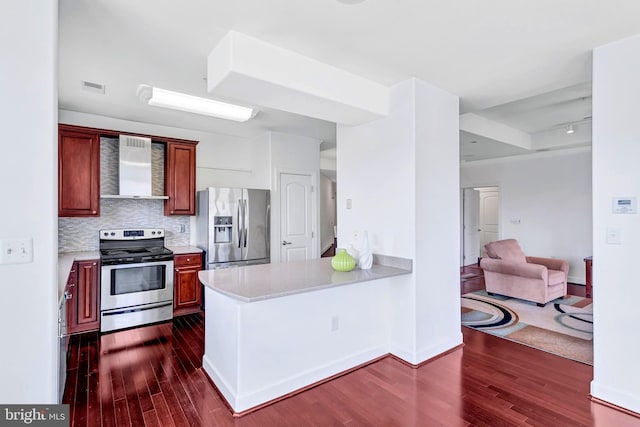 kitchen featuring wall chimney exhaust hood, visible vents, stainless steel appliances, and dark wood-style flooring