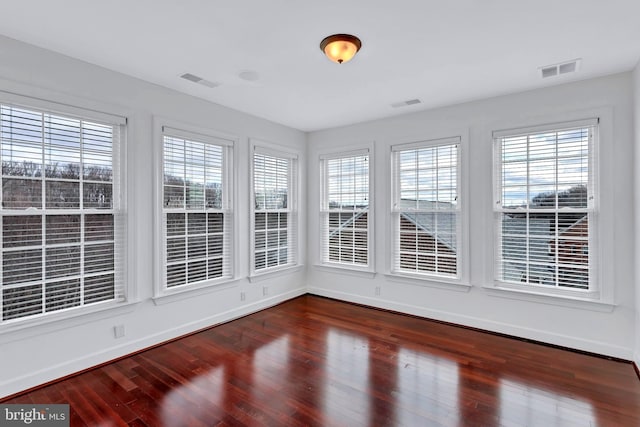 unfurnished sunroom featuring a wealth of natural light and visible vents