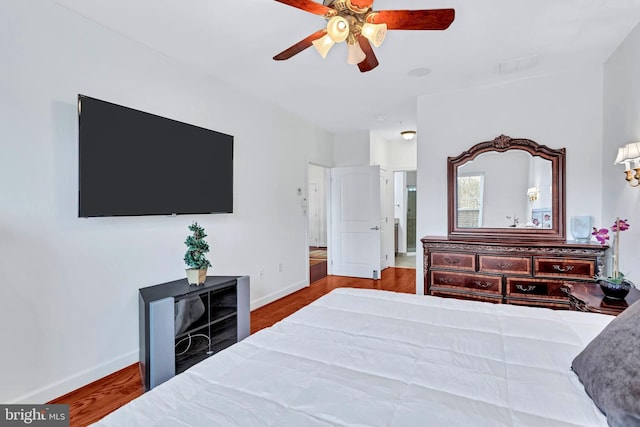 bedroom with a ceiling fan, baseboards, and wood finished floors