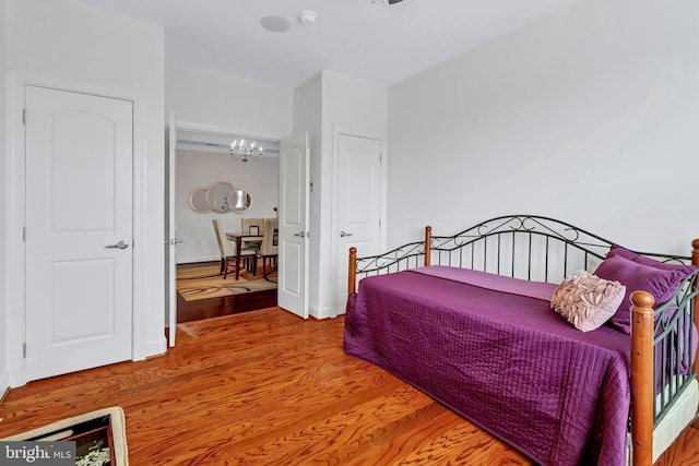 bedroom with a chandelier and wood finished floors