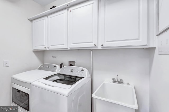 clothes washing area featuring washing machine and clothes dryer, a sink, and cabinet space