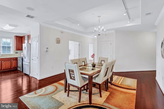 dining area featuring visible vents, a raised ceiling, and dark wood finished floors