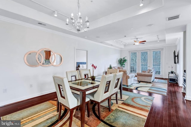 dining area with hardwood / wood-style flooring, visible vents, and a tray ceiling