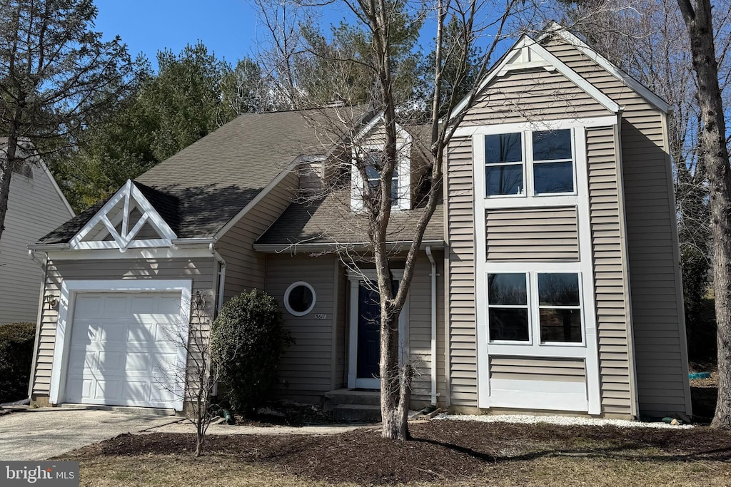 view of front of home featuring driveway, a shingled roof, and an attached garage