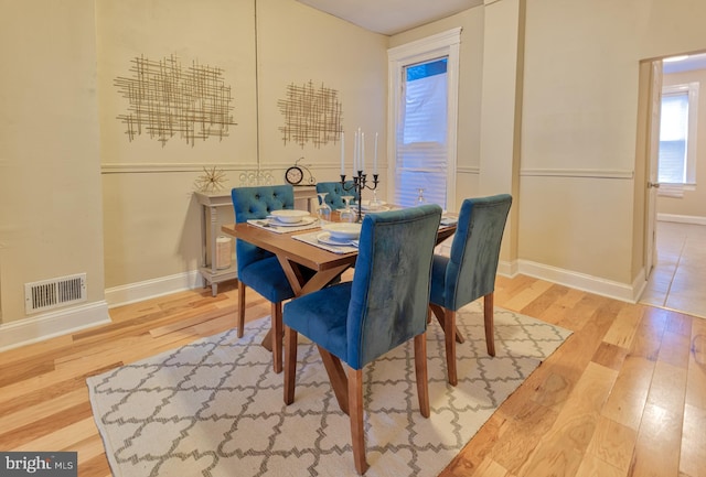 dining room with baseboards, visible vents, and hardwood / wood-style floors