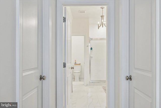 hallway featuring marble finish floor and visible vents