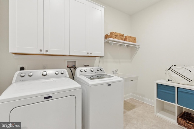 laundry room with washer and dryer, cabinet space, a sink, and baseboards