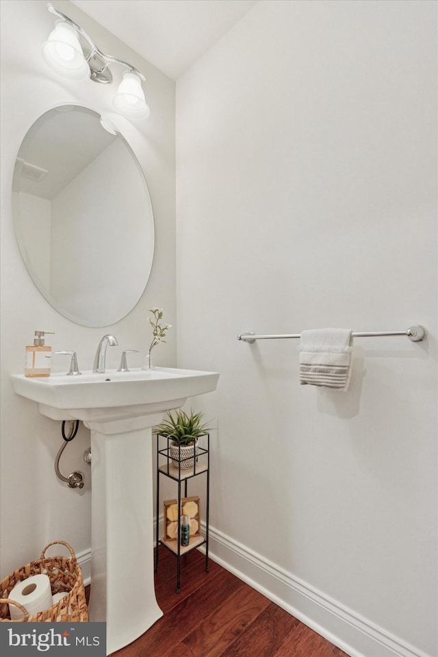 bathroom with baseboards and wood finished floors