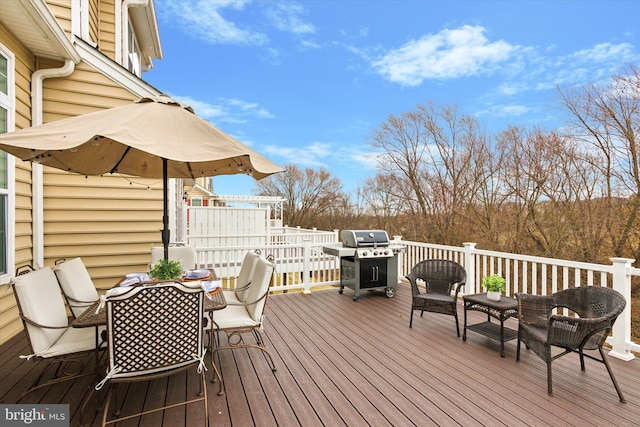 wooden terrace with a grill and outdoor dining area