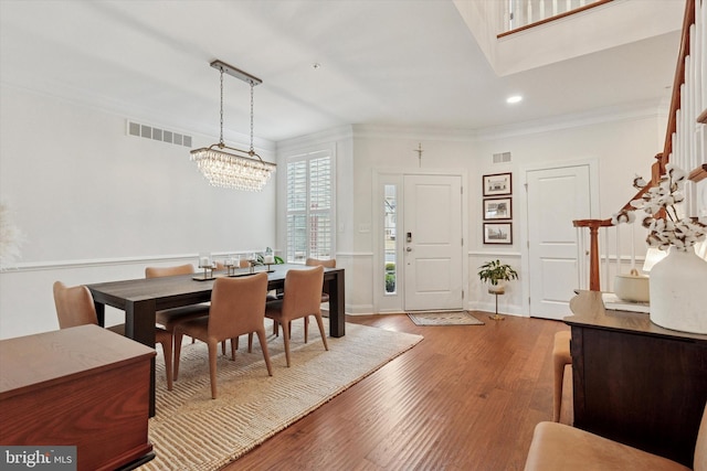 dining space with crown molding, recessed lighting, visible vents, stairway, and wood finished floors