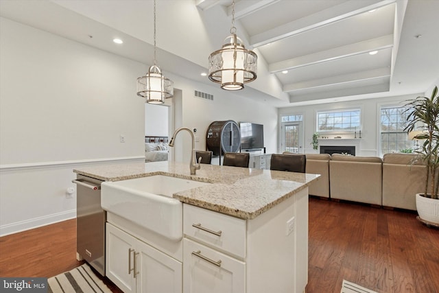 kitchen with dark wood-style flooring, vaulted ceiling with beams, visible vents, open floor plan, and a sink