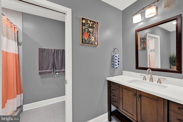 bathroom with a shower with curtain, vanity, baseboards, and tile patterned floors