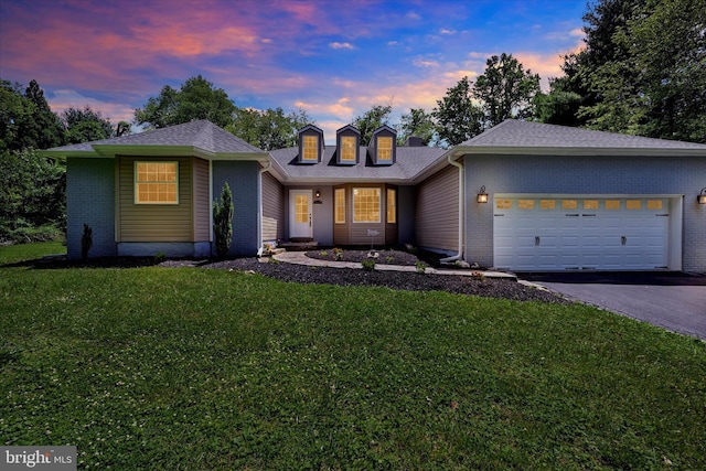 view of front of property featuring a garage, a front yard, brick siding, and driveway