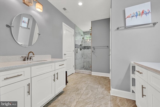 full bathroom with a stall shower, vanity, visible vents, and baseboards