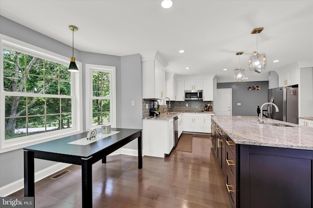 kitchen featuring stainless steel appliances, white cabinets, visible vents, and a sink