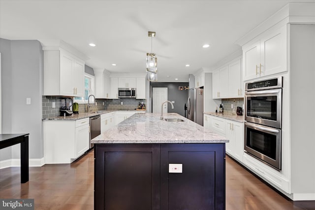 kitchen featuring appliances with stainless steel finishes, white cabinets, and a sink